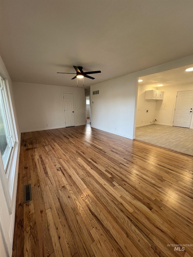 317 Baker Dr, Mountain Home, ID 83647 - unfurnished living room featuring hardwood / wood-style floors, a ceiling fan, and baseboards