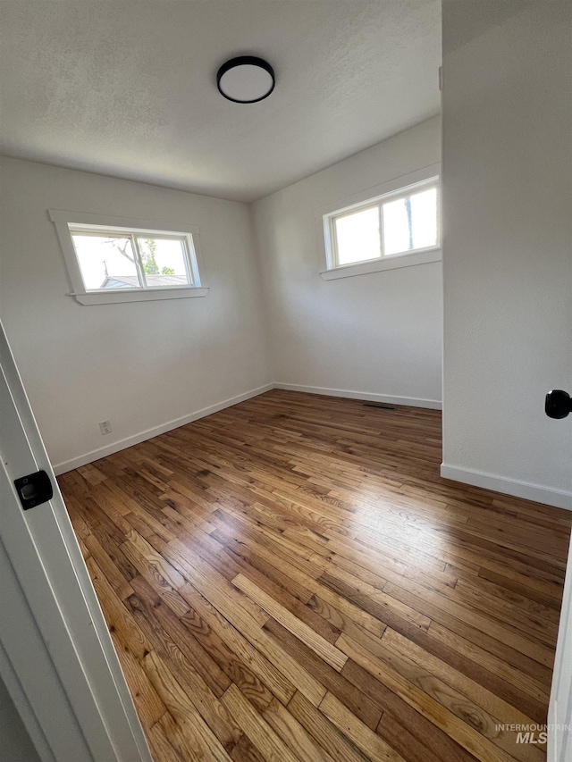 317 Baker Dr, Mountain Home, ID 83647 - unfurnished room with plenty of natural light, wood-type flooring, and baseboards