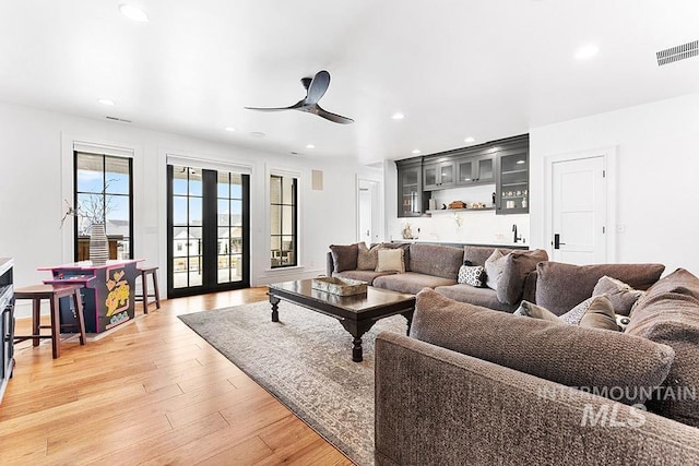 living room featuring ceiling fan, recessed lighting, visible vents, french doors, and light wood finished floors