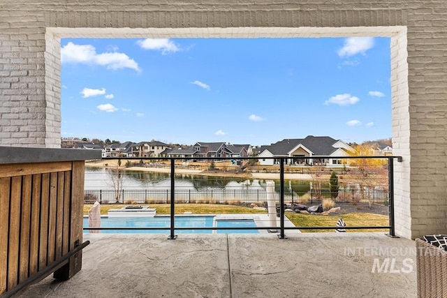 view of swimming pool with a fenced in pool, a residential view, a water view, fence, and a patio area