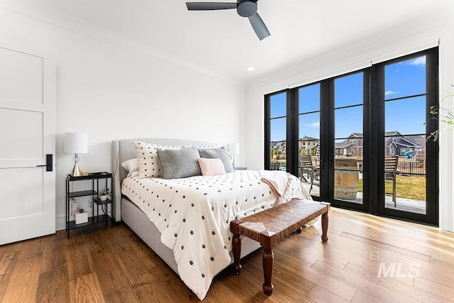 bedroom featuring multiple windows, wood finished floors, and crown molding