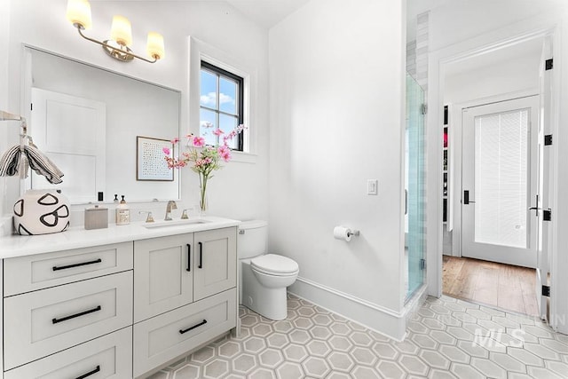 full bath featuring a stall shower, baseboards, toilet, tile patterned floors, and vanity