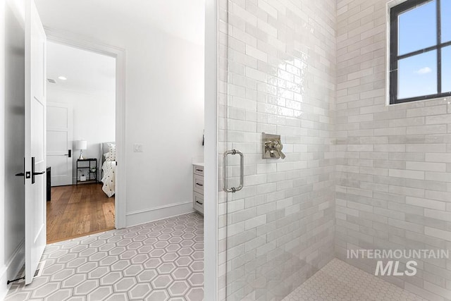 full bath featuring tile patterned flooring, a shower stall, and baseboards