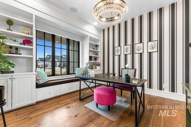 office space featuring light wood finished floors, an inviting chandelier, and wallpapered walls