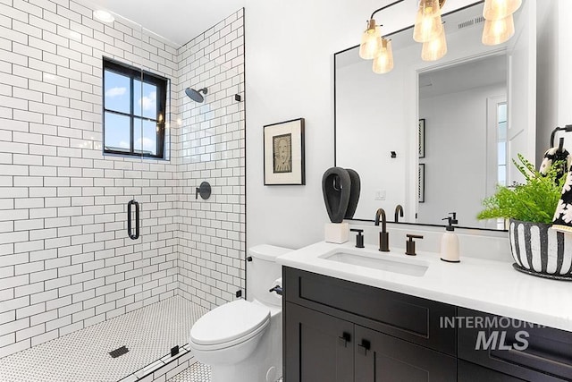 full bathroom featuring visible vents, vanity, a shower stall, and toilet