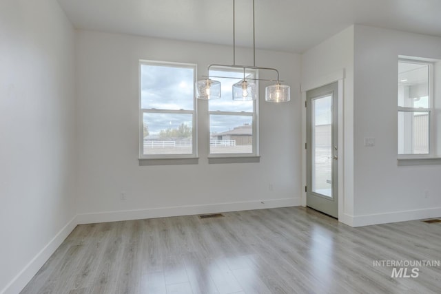 unfurnished dining area featuring a healthy amount of sunlight and light wood-type flooring