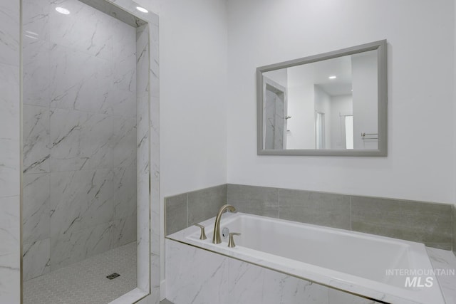 bathroom featuring shower with separate bathtub