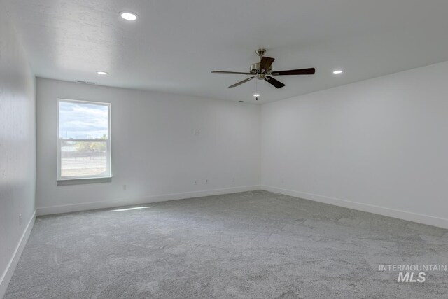 empty room featuring ceiling fan and light carpet