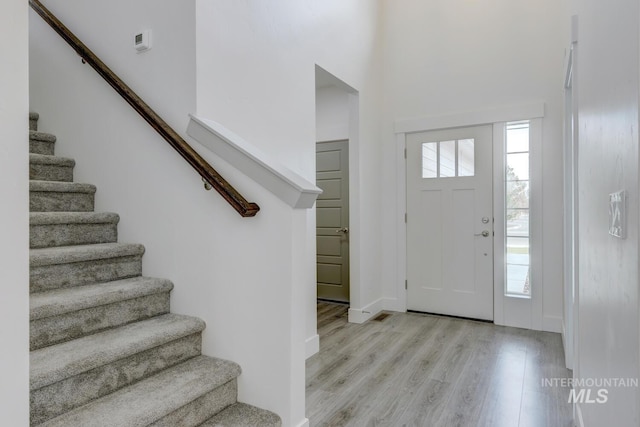 entryway with light wood-type flooring and a high ceiling