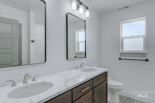 bathroom with tile patterned flooring, plenty of natural light, toilet, and vanity