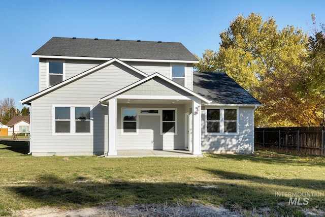 back of property with a patio area and a yard