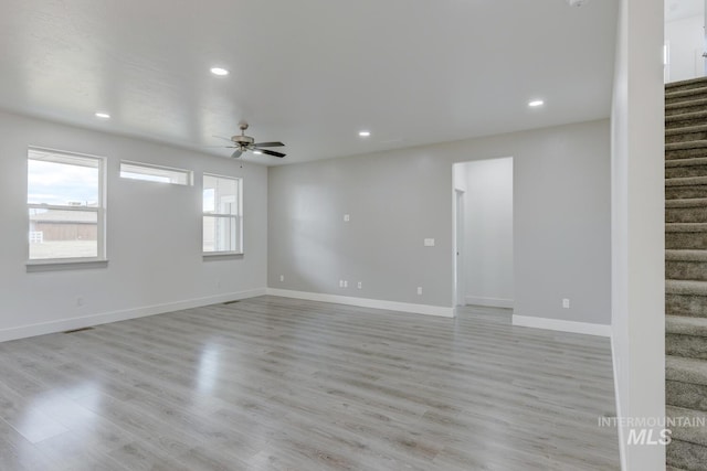 empty room with ceiling fan and light hardwood / wood-style flooring