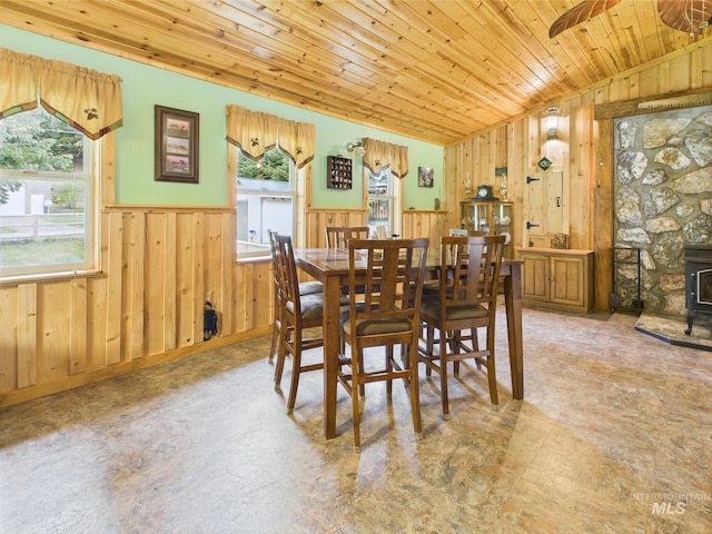 4474 Council Cuprum Rd, Council, ID 83612 - dining area featuring a wood stove, vaulted ceiling, wainscoting, wood walls, and wooden ceiling