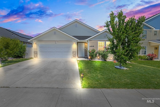 16848 Loggia Ave, Caldwell, ID 83607 - view of front of property featuring driveway, an attached garage, a yard, board and batten siding, and stone siding