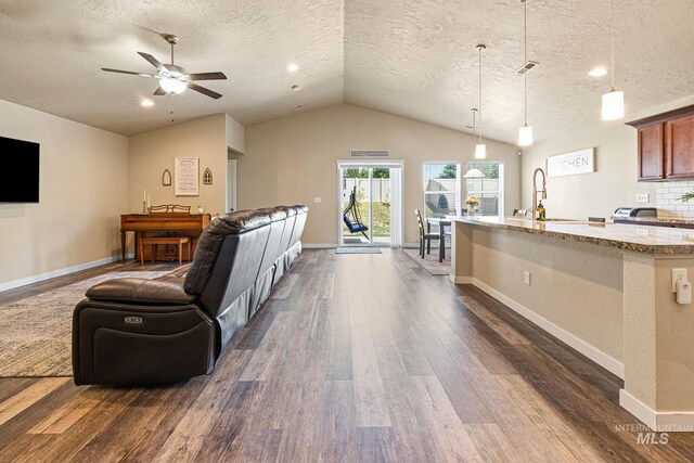 16848 Loggia Ave, Caldwell, ID 83607 - living area featuring dark wood finished floors, a textured ceiling, lofted ceiling, ceiling fan, and baseboards