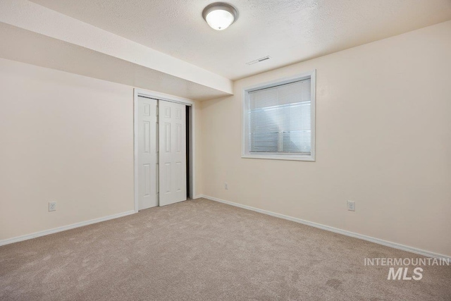 646 W Falls Ave, Twin Falls, ID 83301 - unfurnished bedroom featuring light colored carpet, a closet, and a textured ceiling