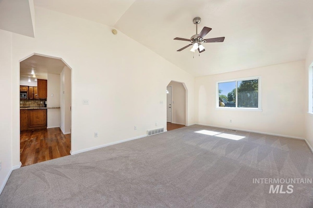 646 W Falls Ave, Twin Falls, ID 83301 - unfurnished living room featuring arched walkways, carpet, vaulted ceiling, and a ceiling fan