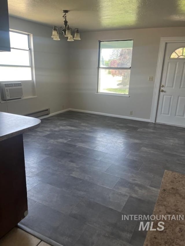 unfurnished dining area with a notable chandelier, cooling unit, and baseboard heating