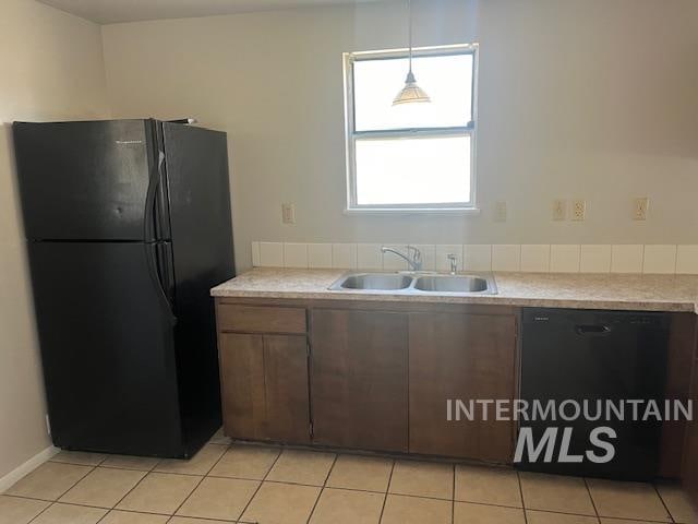 kitchen featuring black appliances, sink, pendant lighting, and light tile patterned floors