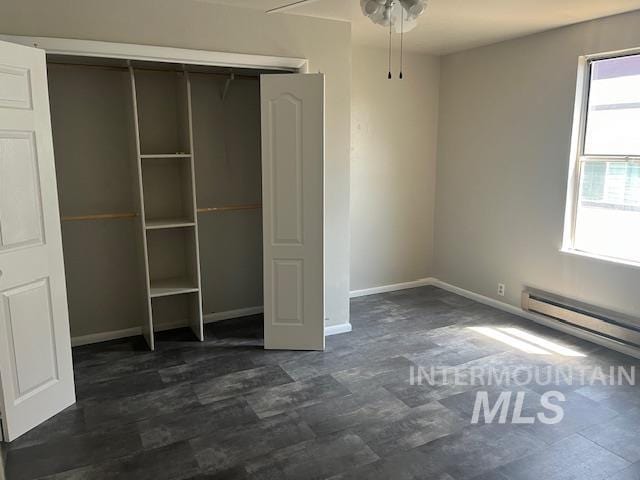 unfurnished bedroom with a closet, ceiling fan, and baseboard heating