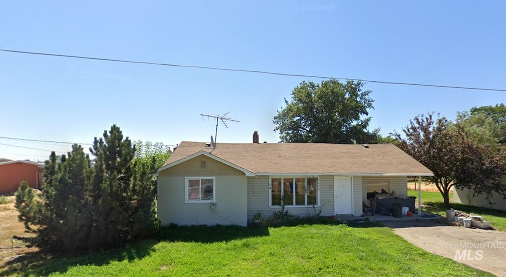 ranch-style home with driveway and a front lawn