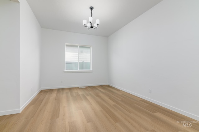 2386 N Leatherwood Ave, Star, ID 83669 - empty room featuring a chandelier, light wood-type flooring, and baseboards