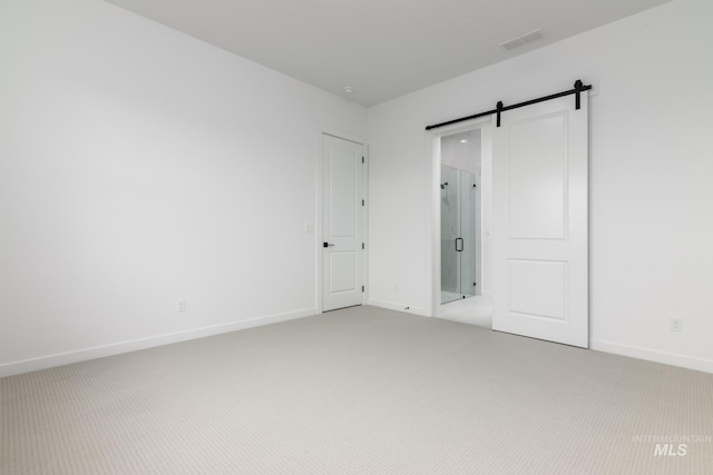 2386 N Leatherwood Ave, Star, ID 83669 - unfurnished bedroom with a barn door, light colored carpet, and baseboards