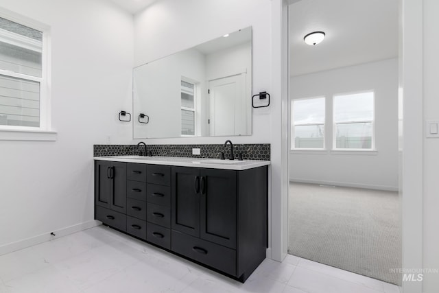 2386 N Leatherwood Ave, Star, ID 83669 - bathroom with baseboards, double vanity, and tasteful backsplash