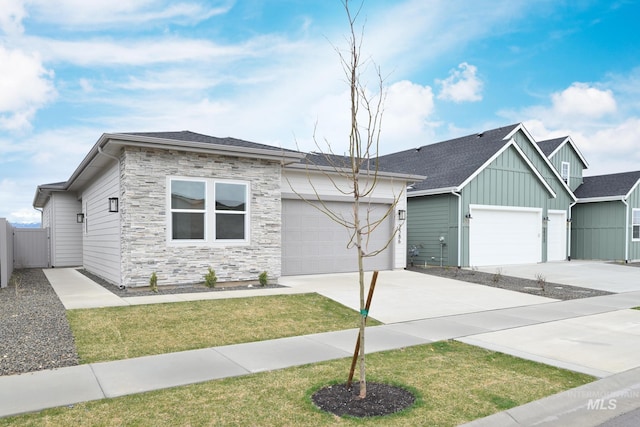2386 N Leatherwood Ave, Star, ID 83669 - view of front of home with board and batten siding, an attached garage, concrete driveway, stone siding, and roof with shingles