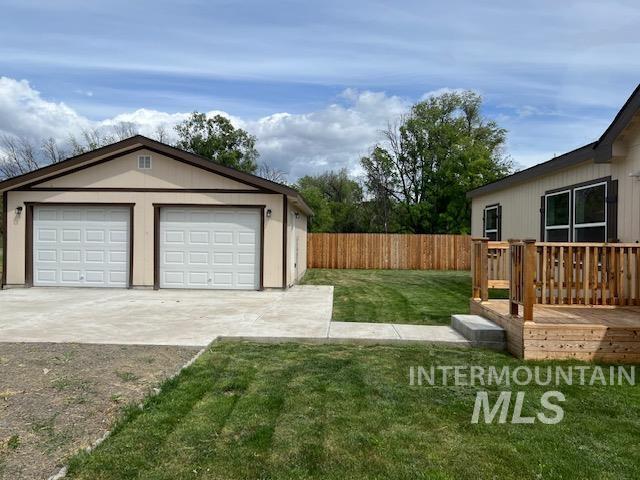 view of yard featuring an outdoor structure, a wooden deck, and a detached garage