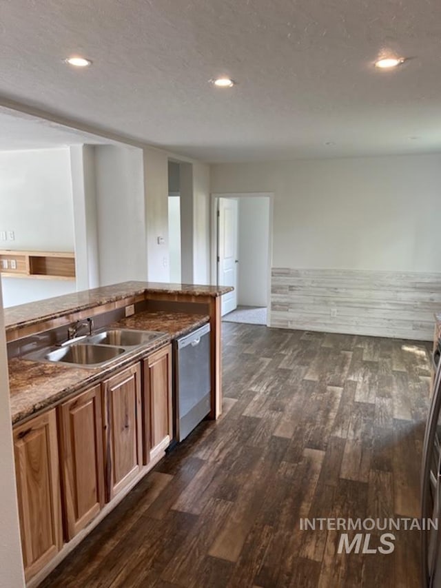 kitchen featuring stainless steel dishwasher, dark wood finished floors, a sink, recessed lighting, and stone countertops
