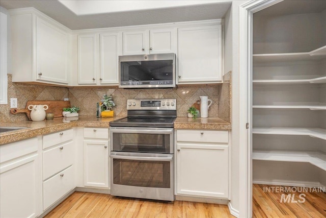 kitchen featuring white cabinetry, light wood-type flooring, and appliances with stainless steel finishes