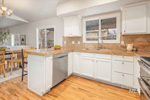 kitchen with a notable chandelier, stainless steel dishwasher, sink, and white cabinets