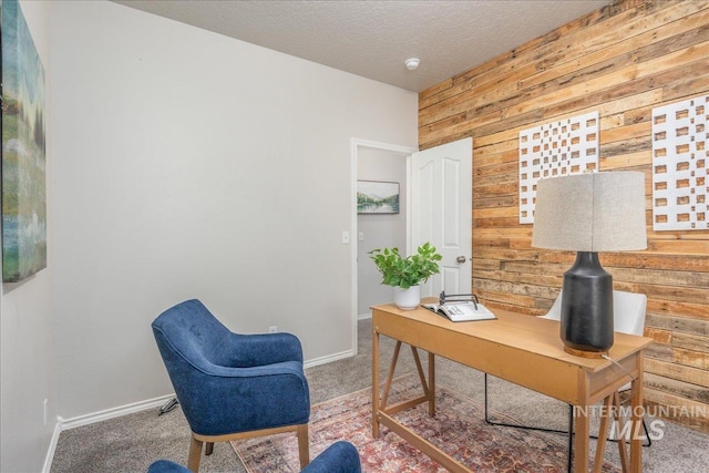 carpeted office with a textured ceiling and wood walls