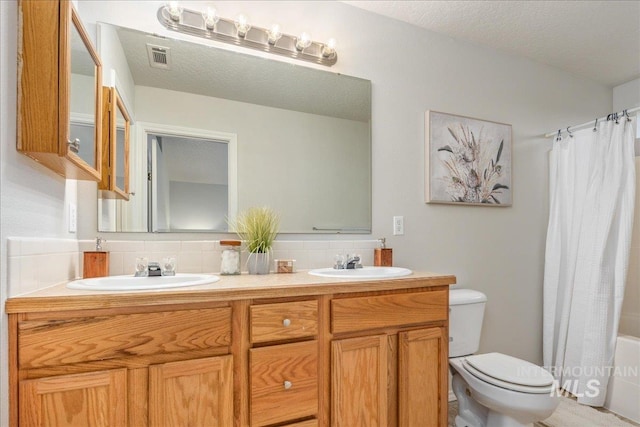 full bathroom with toilet, a textured ceiling, vanity, shower / bath combo, and backsplash