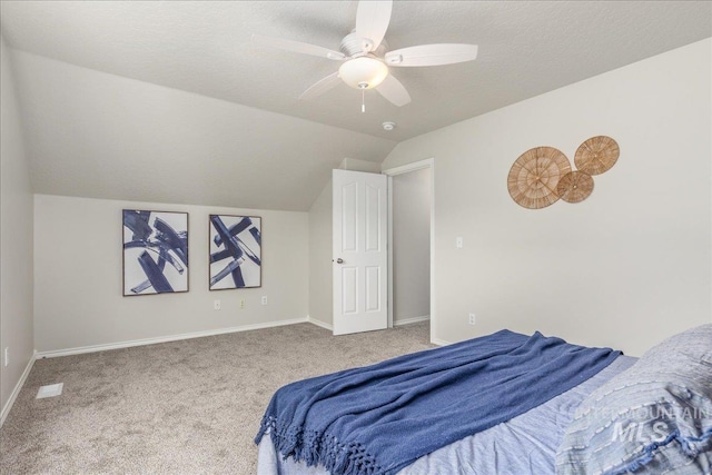 carpeted bedroom featuring ceiling fan, lofted ceiling, and a textured ceiling