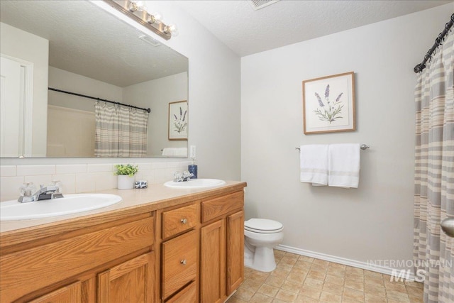 bathroom featuring vanity, backsplash, a textured ceiling, and toilet