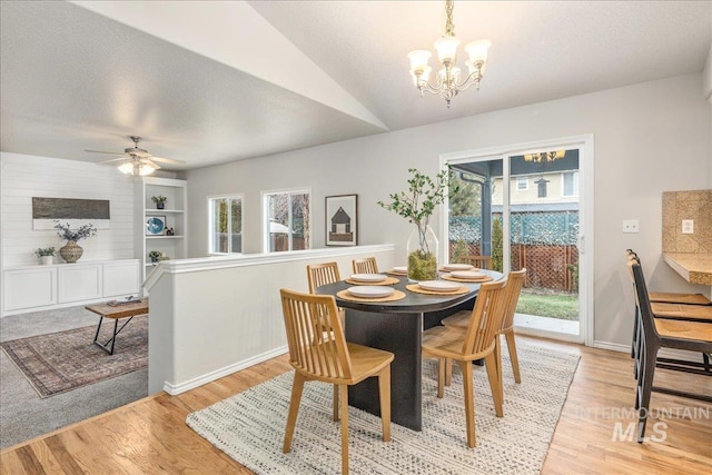 dining space featuring plenty of natural light, ceiling fan with notable chandelier, a textured ceiling, and light hardwood / wood-style floors