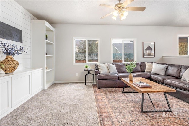 carpeted living room with ceiling fan and a textured ceiling