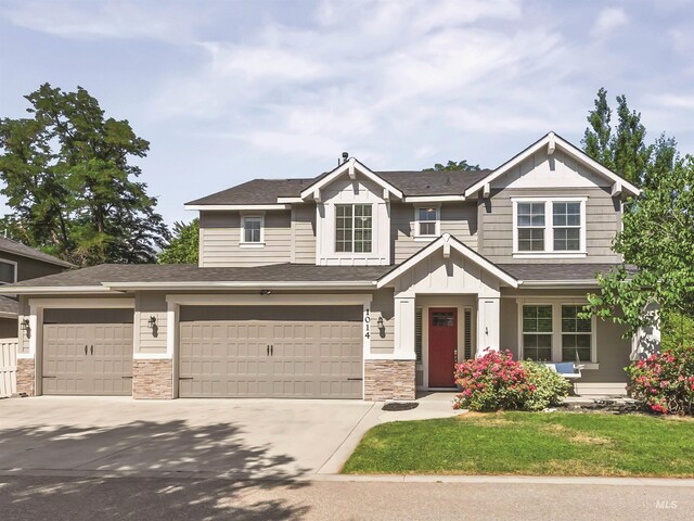 1014 E Carter St, Boise, ID 83706 - view of front of property featuring concrete driveway, stone siding, board and batten siding, roof with shingles, and a front lawn