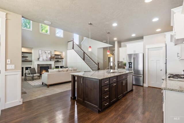 1014 E Carter St, Boise, ID 83706 - kitchen featuring appliances with stainless steel finishes, dark brown cabinetry, a tiled fireplace, white cabinets, and recessed lighting