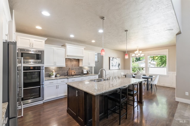 1014 E Carter St, Boise, ID 83706 - kitchen featuring appliances with stainless steel finishes, dark wood-style floors, white cabinets, light stone counters, and a textured ceiling