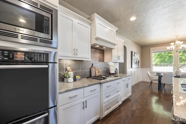 1014 E Carter St, Boise, ID 83706 - kitchen featuring stainless steel appliances, a textured ceiling, a chandelier, dark wood finished floors, and white cabinetry