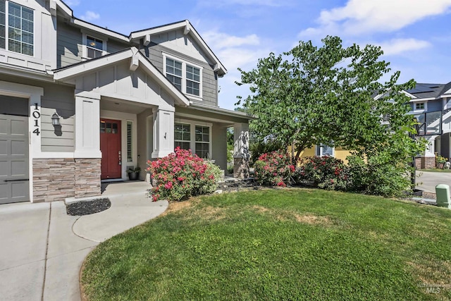 1014 E Carter St, Boise, ID 83706 - view of front of house featuring a front yard, board and batten siding, stone siding, and a garage