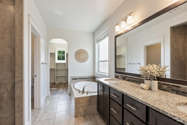 1014 E Carter St, Boise, ID 83706 - bathroom featuring double vanity, a bath, tile patterned flooring, and a walk in closet