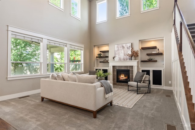 1014 E Carter St, Boise, ID 83706 - living room featuring a tiled fireplace, a towering ceiling, carpet floors, and stairway