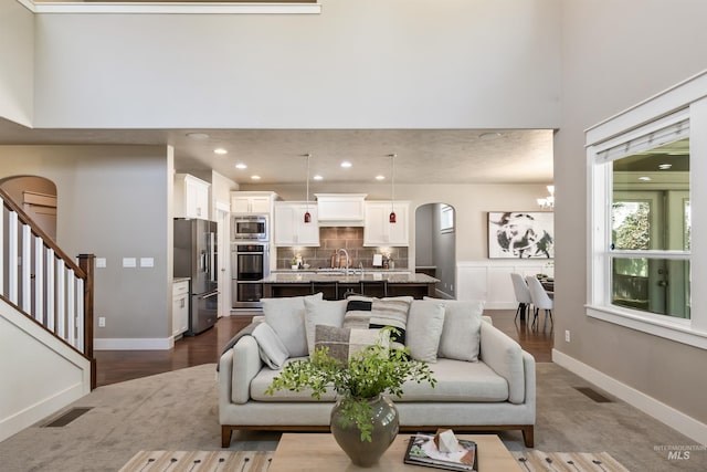 1014 E Carter St, Boise, ID 83706 - living room with a chandelier, arched walkways, recessed lighting, a high ceiling, and stairs