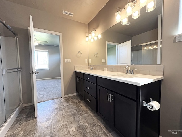 1786 E Cave Falls St, Kuna, ID 83634 - full bathroom featuring double vanity, tasteful backsplash, baseboards, a shower with shower door, and stone finish flooring