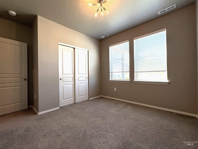 1786 E Cave Falls St, Kuna, ID 83634 - unfurnished bedroom featuring carpet flooring, a closet, baseboards, and a chandelier