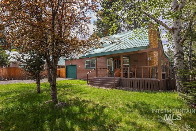 1102 Davis, Mccall, ID 83638 - view of front of house with an attached garage, a chimney, driveway, and metal roof